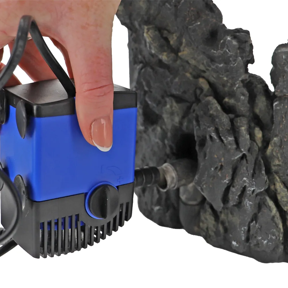 Hobby Sandfall (25,5 × 20 × 26,5 cm) Aquarium-Dekoration: dunkle Felsstruktur mit seitlichem Tüllenanschluss und angeschlossener blauer Aquarienpumpe, zeigt Anschluss für den unterwasser Sandfall-Effekt