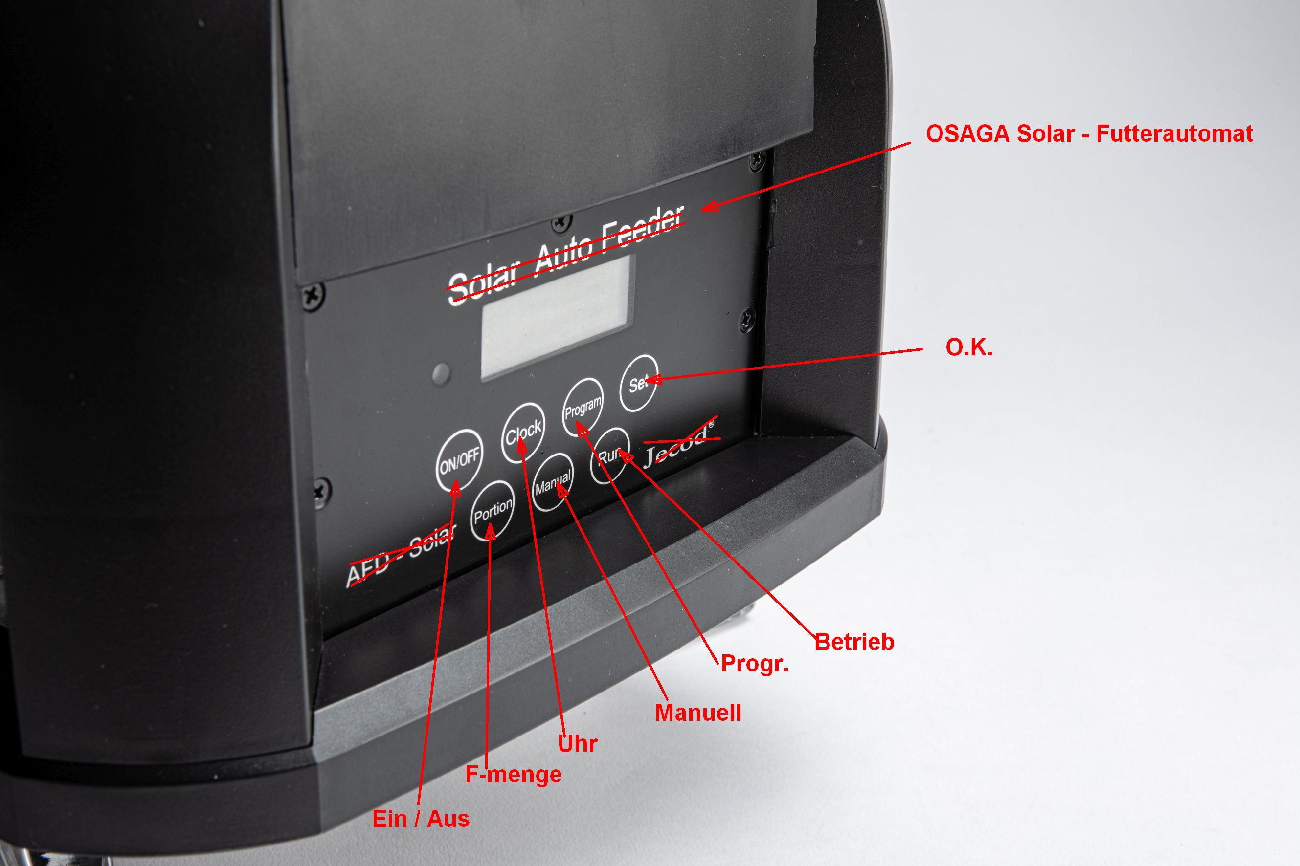 Nahaufnahme des Bedienfelds eines schwarzen OSAGA Solar Futterautomaten mit LCD-Display und beschrifteten Tasten: ON/OFF, Portion, Clock, Manual, Program, Set; rote Markierungen und Pfeile zeigen die Bedienelemente.