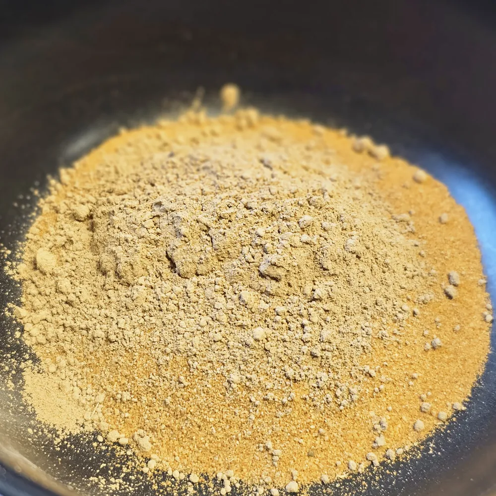Haufen gelbes Lehmpulver (Hobby Terrano Clay Powder) in Schüssel, fein gemahlenes, rein mineralisches Bindemittel zur Stabilisierung von Terrarienböden, bindet Sand und Erde, 1,3 kg